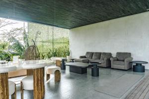 a lobby with chairs and tables and a couch at Amulya Luxury Villa, Dago - 4BR Heated Infinity Pool in Bandung