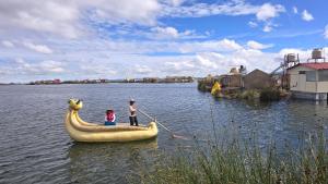two people in a banana boat in the water at Samca Titicaca Lodge Puno Peru in Puno