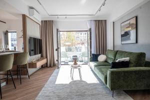 a living room with a green couch and a table at CHANTTAL Luxury - AMZEI in Bucharest