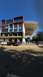 a large building with cars parked in a parking lot at shreehariom in Ahmedabad