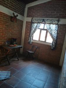 a room with a window with a table and a chair at La Casa del Abuelito in San Miguel Regla