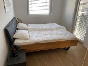 a bed with white sheets and pillows in a bedroom at Panorama View - CharmingStay in Flumserberg