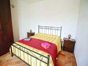 a bedroom with a bed with a red and yellow blanket at Cottage in Asciano with Pool and Terrace in Asciano