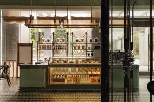 a display case in a restaurant with bottles of alcohol at Capella Taipei in Taipei