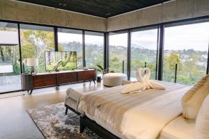 a bedroom with a large bed and large windows at Amulya Luxury Villa, Dago - 4BR Heated Infinity Pool in Bandung +39 photos