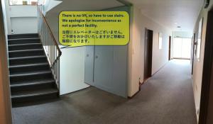 un corridoio con scale e un cartello sul muro di Sunshine Kyohei a Nozawa Onsen 1 altra foto