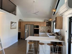 a kitchen with a white counter and bar stools at Salt Ayres in Horseshoe Bay