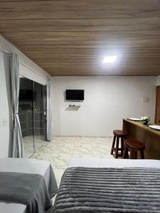 una camera da letto con due letti e una TV a parete di Flats Rota dos Corais a São Miguel dos Milagres