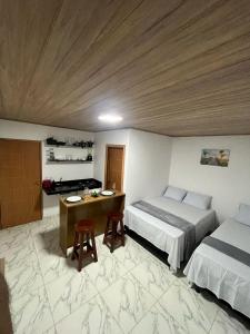 una camera da letto con due letti e una scrivania di Flats Rota dos Corais a São Miguel dos Milagres