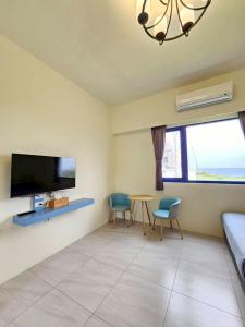 a living room with a tv and a table and chairs at 綠島209角落Corner of Green Island 台東縣民宿編號第2003號 in Green Island +19 photos