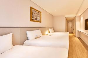 Un pat sau paturi într-o cameră la Hotel Thomas Myeongdong