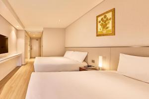 Un pat sau paturi într-o cameră la Hotel Thomas Myeongdong
