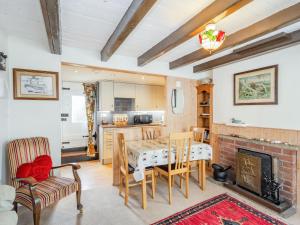a kitchen and living room with a table and a fireplace at Duck Cottage in Bridlington
