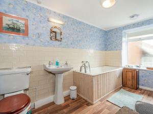 a bathroom with a sink and a tub and a toilet at Duck Cottage in Bridlington +15 photos