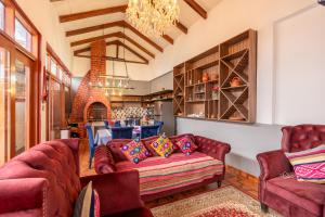 a living room with red couches and a fireplace at Colonial Home Chachapoyas in Chachapoyas