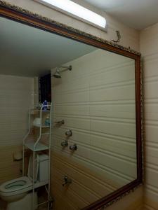 a mirror in front of a bathroom with a toilet at Luxury 3 bed apartment in Dhaka