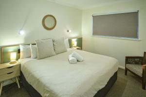 a bedroom with a large white bed with a chalkboard on the wall at Oceanhaus - Margaret River in Margaret River Town
