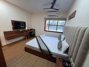 a large room with a bed and a television at Shaan-E-Punjab Nirsa in Dhanbād