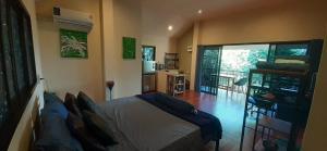 ein Schlafzimmer mit einem Bett und einem großen Fenster in der Unterkunft Butterfly Cottage Tracy Island Had Yao in Ko Phangan