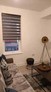 a living room with a couch and a window at Cohost Partners 3 Bed Apartment in Warrington in Warrington +3 photos