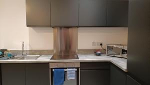 a kitchen with a sink and a stove top oven at Cohost Partners 3 Bed Apartment in Warrington in Warrington