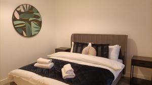 a bedroom with a bed with towels on it at Cohost Partners 3 Bed Apartment in Warrington in Warrington