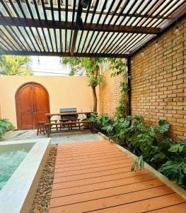 a patio with a wooden walkway and a table and bench at Cherish Villa - Near Mountain and Beach - Sơn Trà in Da Nang
