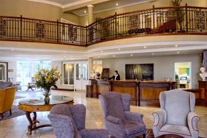 a living room with a staircase and a table and chairs at Hotel Woodstock Ennis in Ennis