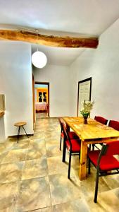 a dining room with a wooden table and red chairs at Hera palace boutique otel in Yialousa