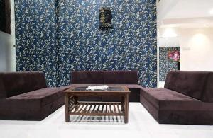 a living room with two couches and a coffee table at Townhouse Bargi Hills Formerly Hotel Sharma in Jabalpur