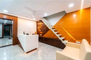 a staircase in a living room with wooden walls at Townhouse Bargi Hills Formerly Hotel Sharma in Jabalpur