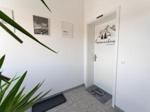 a hallway with a door with a sign on it at Ferienwohnung Anemone - 4 Zimmer mit Bergblick & Alpenflair in Germaringen