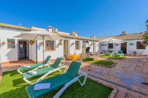 un patio con due sedie da giardino e un ombrellone di Rural House with exclusive pool in Cordoba a Rivero de Posadas