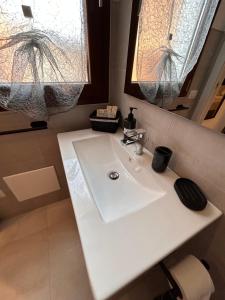 a bathroom with a white sink and two windows at Vista d'Ogliastra in Gàiro SantʼElena