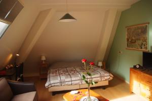 a bedroom with a bed and a table with flowers on it at B&B Noflik Haule in Haule