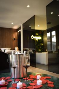 two wine glasses sitting on top of a table at L'Escapade - Love room & spa in Haguenau +25 photos