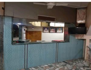 una cucina con un bancone blu e uno specchio di Hotel Sangam sagar a Sāgar