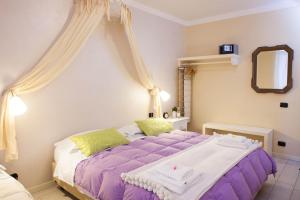 1 dormitorio con cama morada y espejo en Botton d'Oro Pelabrocco, en Bérgamo