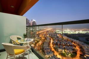 Modern High-Floor 1BR Apartment with Balcony, Pool Access & Golf Course View, Up to 4 Guests, by Stayfinity في دبي: اطلالة على المدينة ليلا من الشرفة