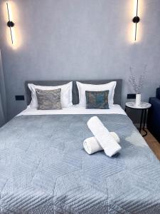 a bedroom with a bed with two towels on it at Современный отдых в сердце города in Almaty