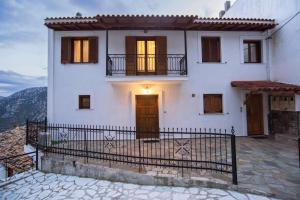 a white house with a balcony and a gate at Delphi View - 3 Bedrooms apartment, fully equipped in Delphi