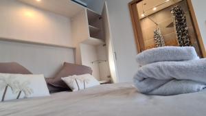 a pile of towels sitting on top of a bed at Appart Hôtel Le Ptit Bec in Bègles