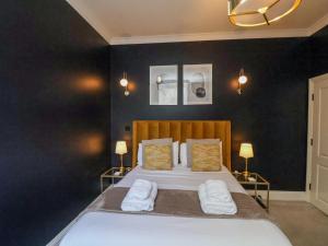 a bedroom with a bed with two white towels on it at The Salisbury 1 Bed Classic Apartment in Scarborough +13 photos