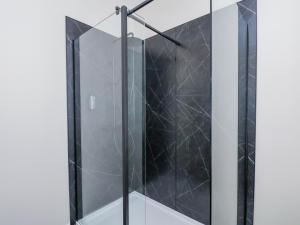 a shower with black tile and a glass door at The Salisbury 1 Bed Classic Apartment in Scarborough