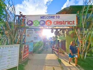 a person walking under a welcome to dogs district sign at Suites by Eco Hotels in El Nido