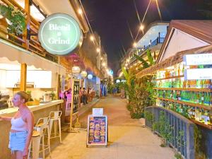 a woman standing in front of a store at night at Suites by Eco Hotels in El Nido