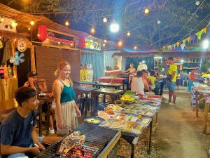 a woman standing in front of a table of food at Suites by Eco Hotels in El Nido