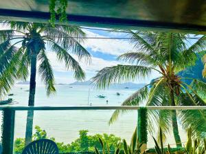 a view of the ocean from a resort with palm trees at Suites by Eco Hotels in El Nido