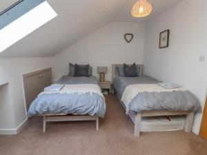 two twin beds in a room with a attic at 5 Stad Clynnog in Llanfairpwllgwyngyll