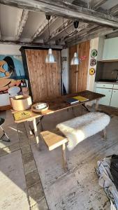 a table and bench in a room with a kitchen at Appartement au cœur des montagnes in Métabief